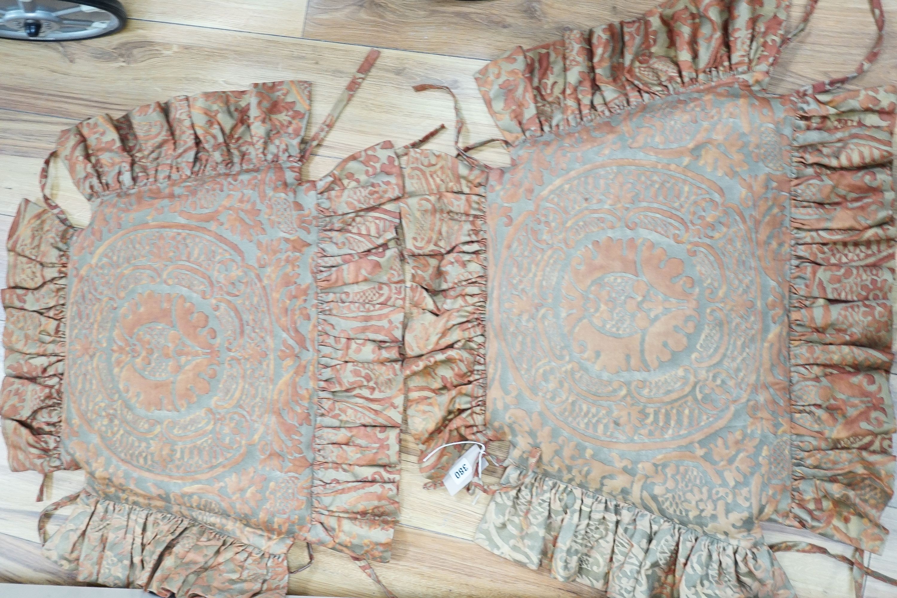 A pair of Fortuni 'Orsini pattern' seat cushions in rust and gold colourway